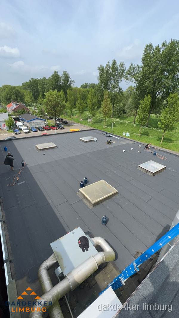 Dakdekker aan het werk op groot plat dak met bitumen in Limburg Dakdekker aan het werk op groot plat dak met bitumen in Limburg