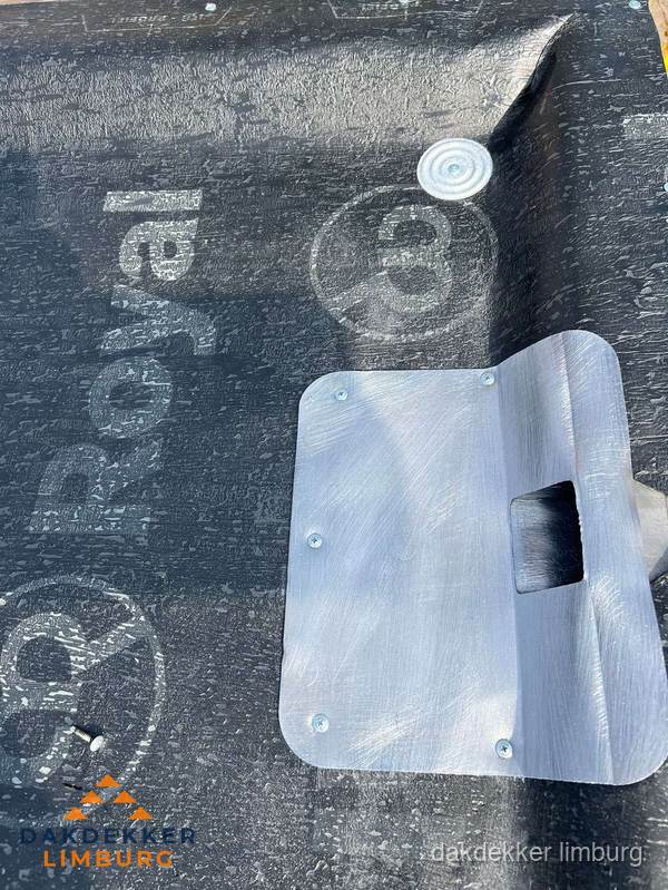 Dakdoorvoer met metalen afvoerplaat op bitumen dak in Limburg