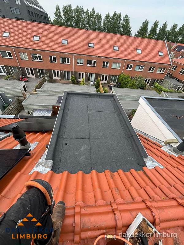 Bitumen dak reparatie op plat dak tussen dakpannen in Limburg