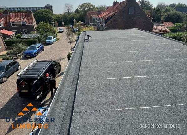 Nieuw bitumen plat dak met uitzicht over woonwijk in Limburg