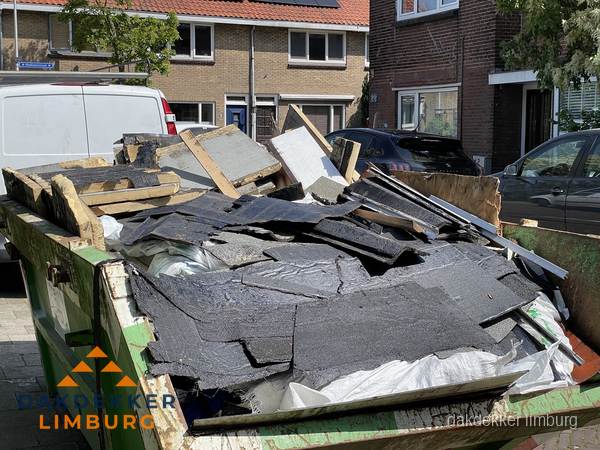 Afvalcontainer met gesloopt dakmateriaal tijdens dakkapel renovatie in Limburg Afvalcontainer met gesloopt dakmateriaal tijdens dakkapel renovatie in Limburg
