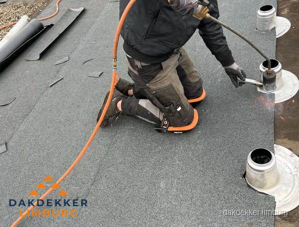 Dakdekker repareert bitumen dakleer bij dakdoorvoer in Limburg Dakdekker repareert bitumen dakleer bij dakdoorvoer in Limburg